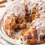 monkey bread with icing on plate with section missing