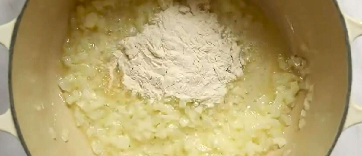 Adding flour to the skillet with onions.