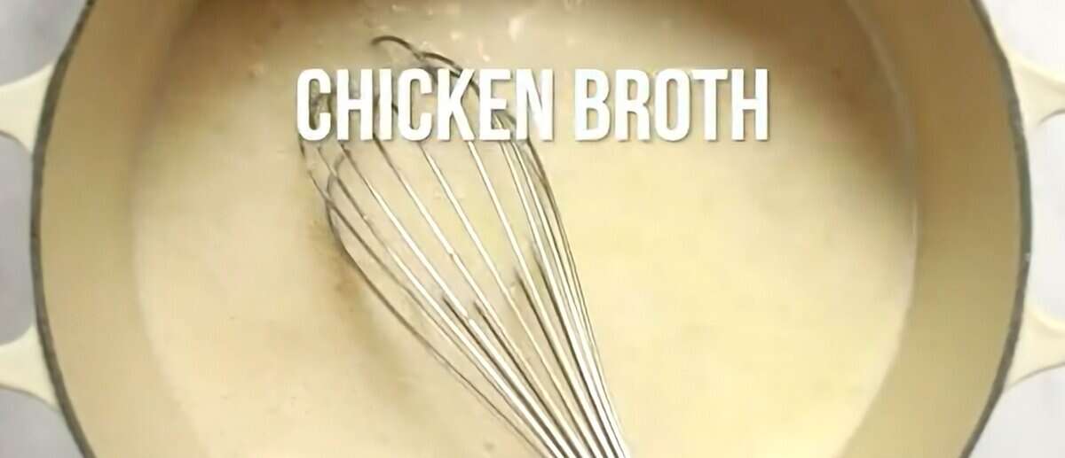 Adding milk and chicken broth to the skillet and stirring with a whisk.