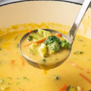 ladle full of cheddar cheese soup with broccoli