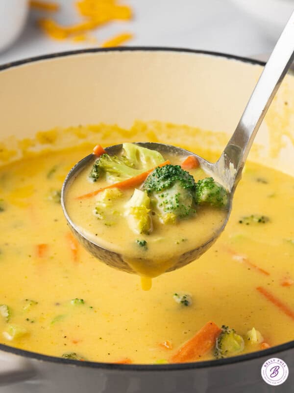 ladle full of cheddar cheese soup with broccoli