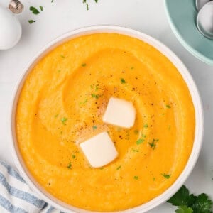 overhead bowl of butternut squash mashed potatoes with 2 pats of butter