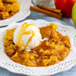 Serving of caramel apple dump cake in a white bowl.