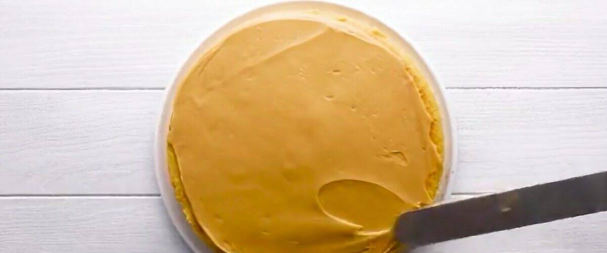 Spreading the frosting over the bottom cake.