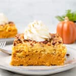 A slice of pumpkin dump cake topped with whipped cream