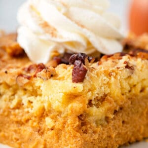 A slice of pumpkin dump cake topped with whipped cream