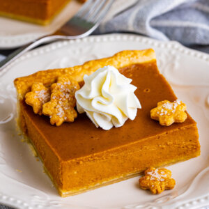 Angled overhead view of a slice of pumpkin slab pie on a white plate