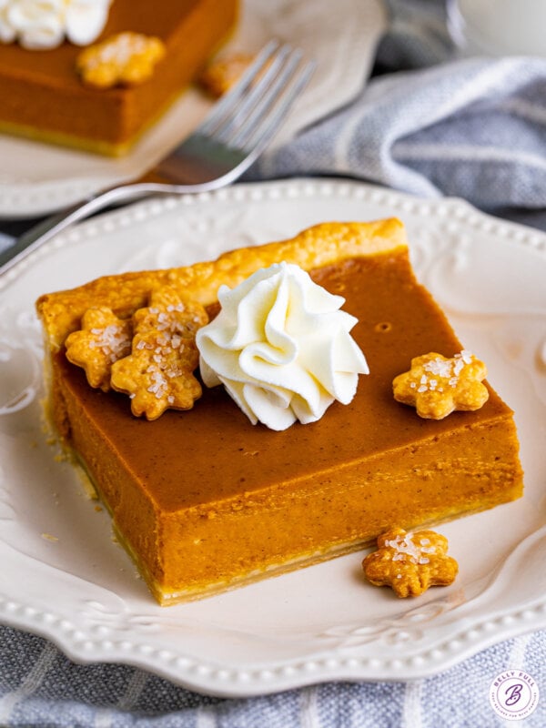 Angled overhead view of a slice of pumpkin slab pie on a white plate