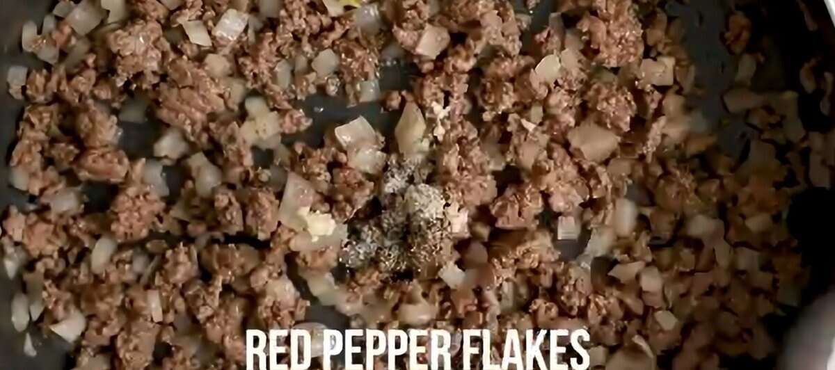 Cooking ground beef, onions, and seasonings in a skillet.