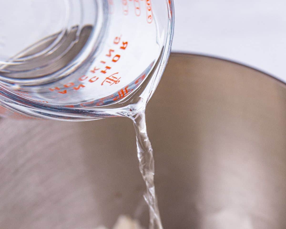 Adding water to the dough mixture.