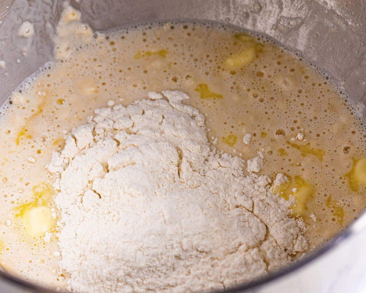 Adding flour to the dough mixture.