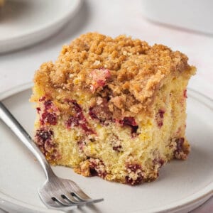 square slice of cranberry buckle coffee cake on white plate