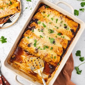 overhead cranberry turkey enchiladas in baking dish with serving spatula