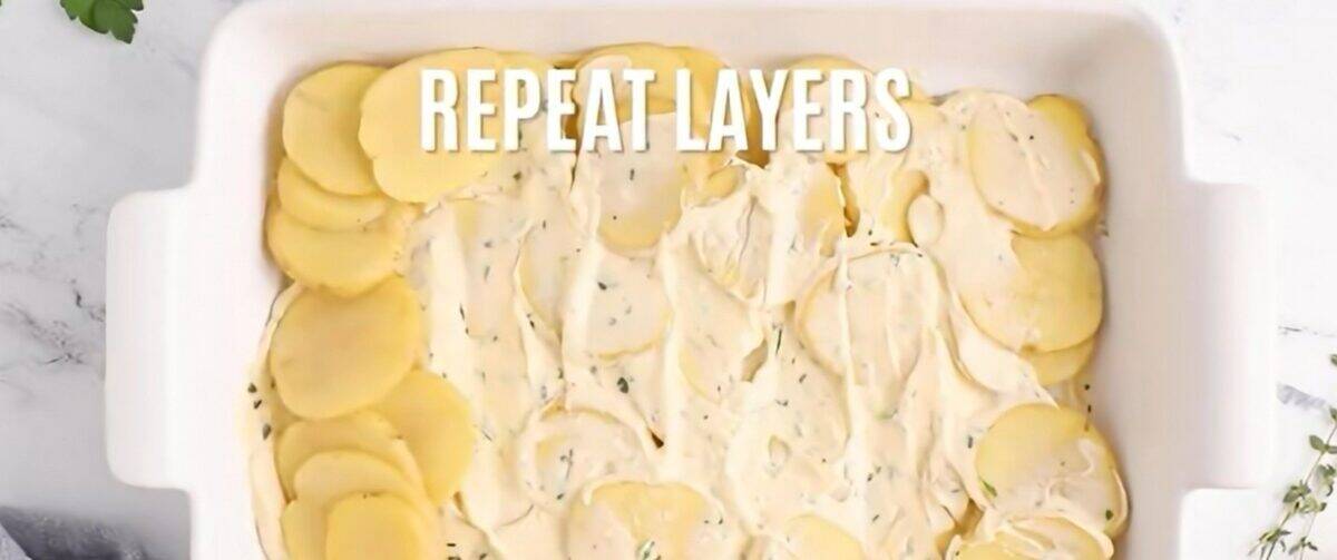 Layering the ingredients for the scalloped potatoes in the baking dish.