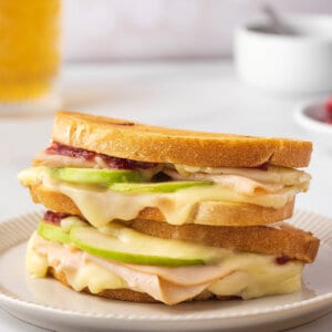 Two turkey brie grilled cheese sandwiches stacked on each other