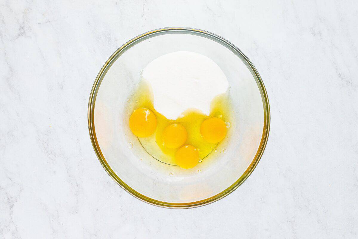 Eggs and sugar in a glass bowl.