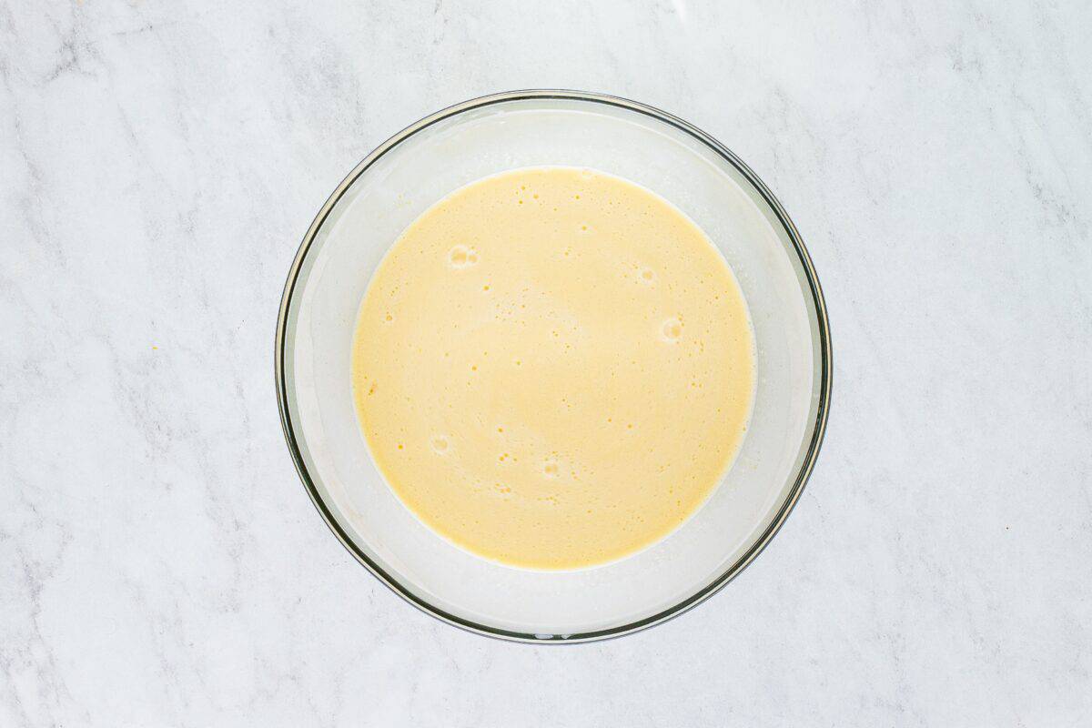 Adding milk, cream, and vanilla to the eggs and sugar.