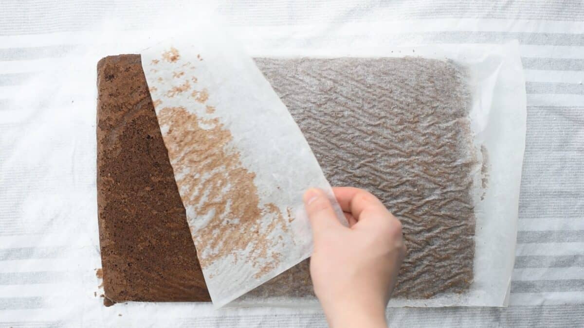 Removing the parchment paper from the cake.