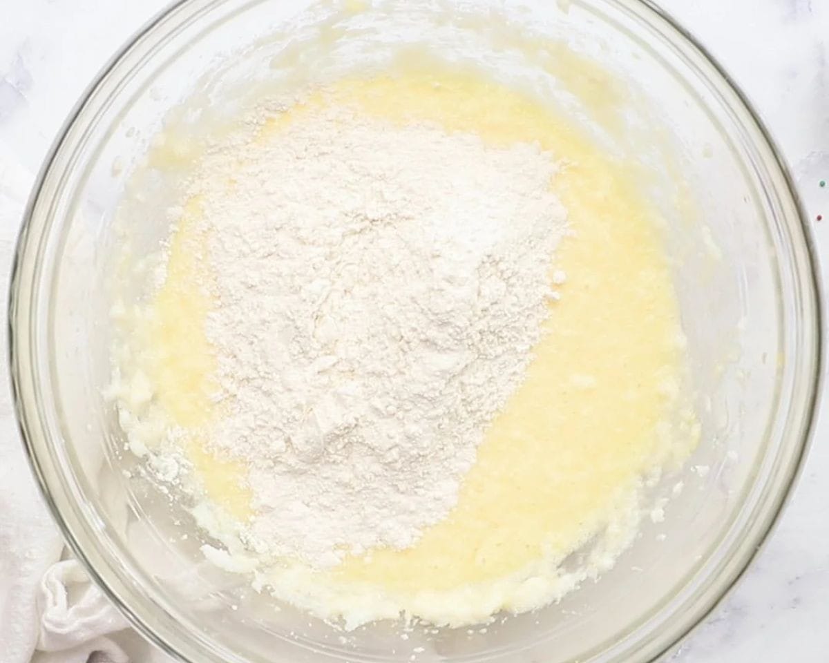 Adding flour to creamed butter and sugar. 