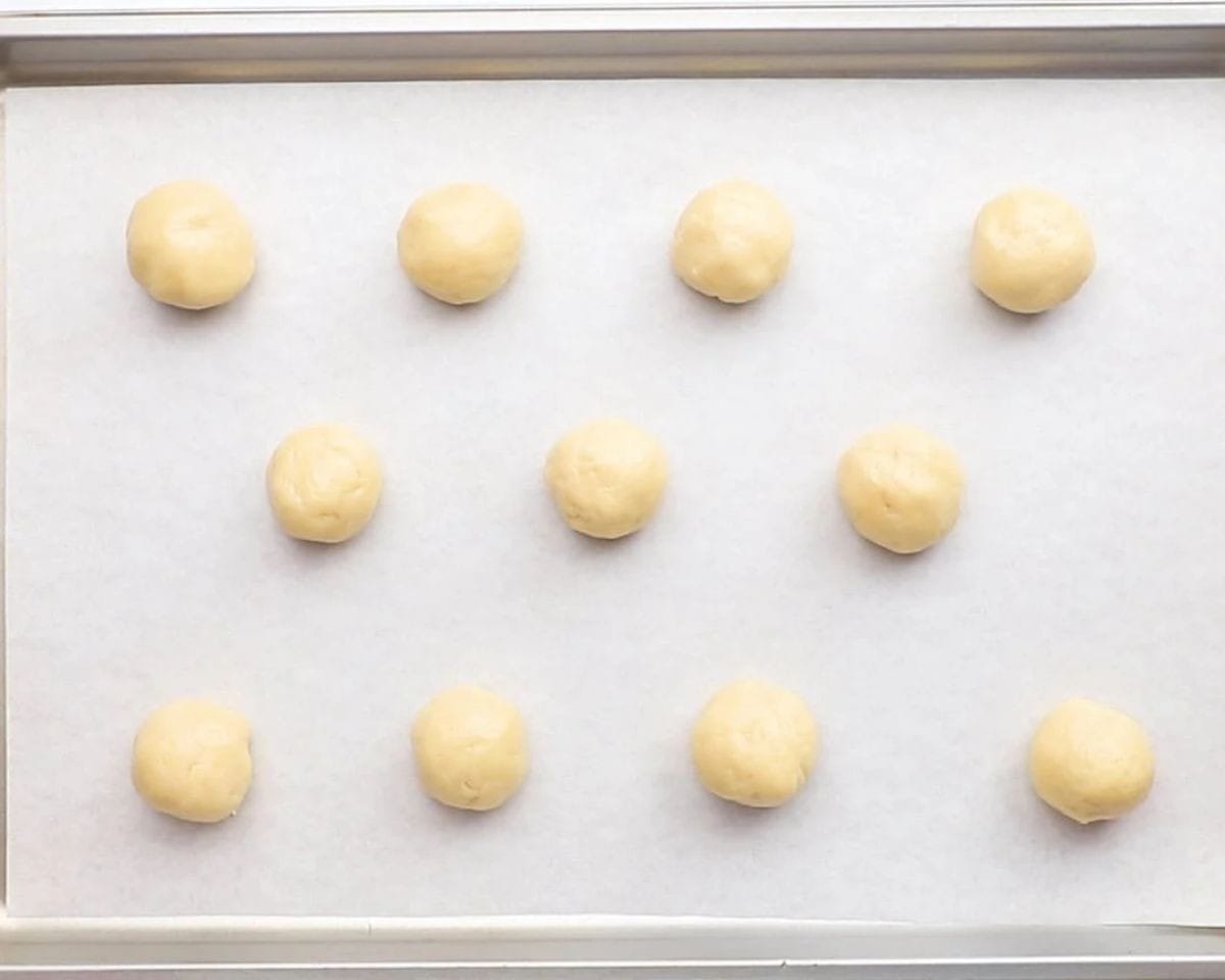 Cookie dough balls on a cookie sheet. 