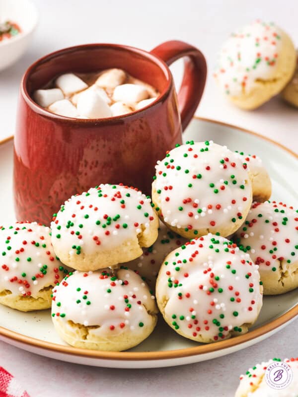 Stack of Christmas Italian cookies next to cup of hot chocolate