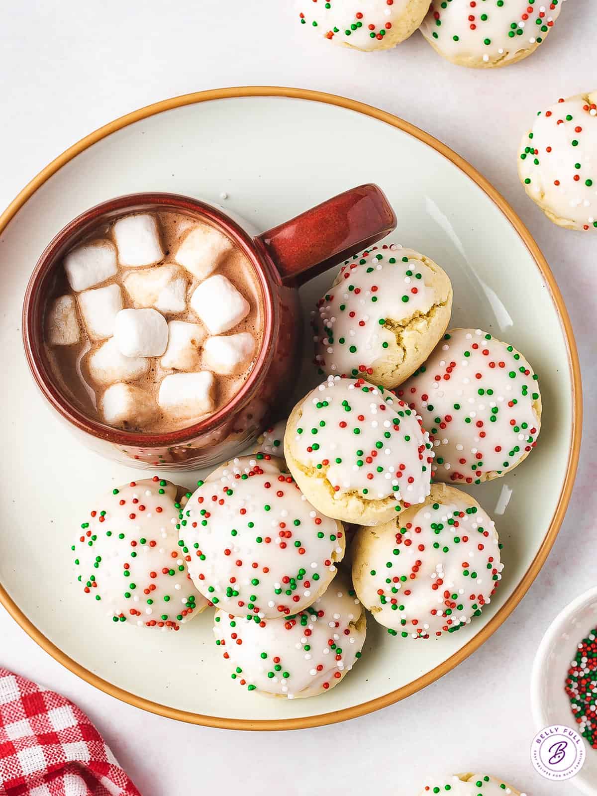 overhead pile of Christmas sugar cookies with cup of hot cocoa