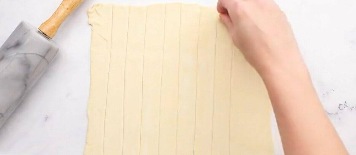 Cutting the pastry into strips.