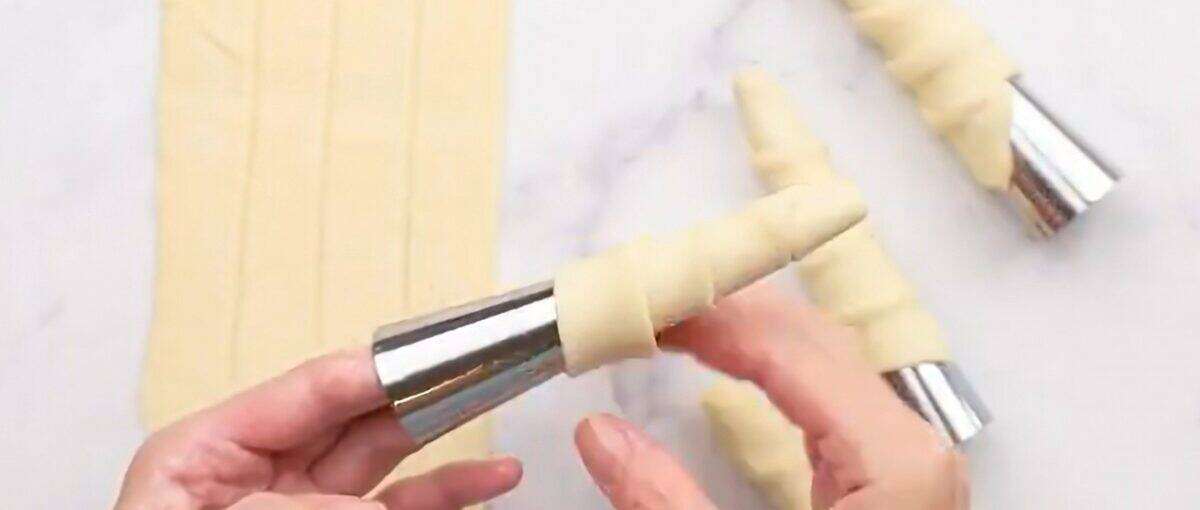 Wrapping the pastry around the mold.