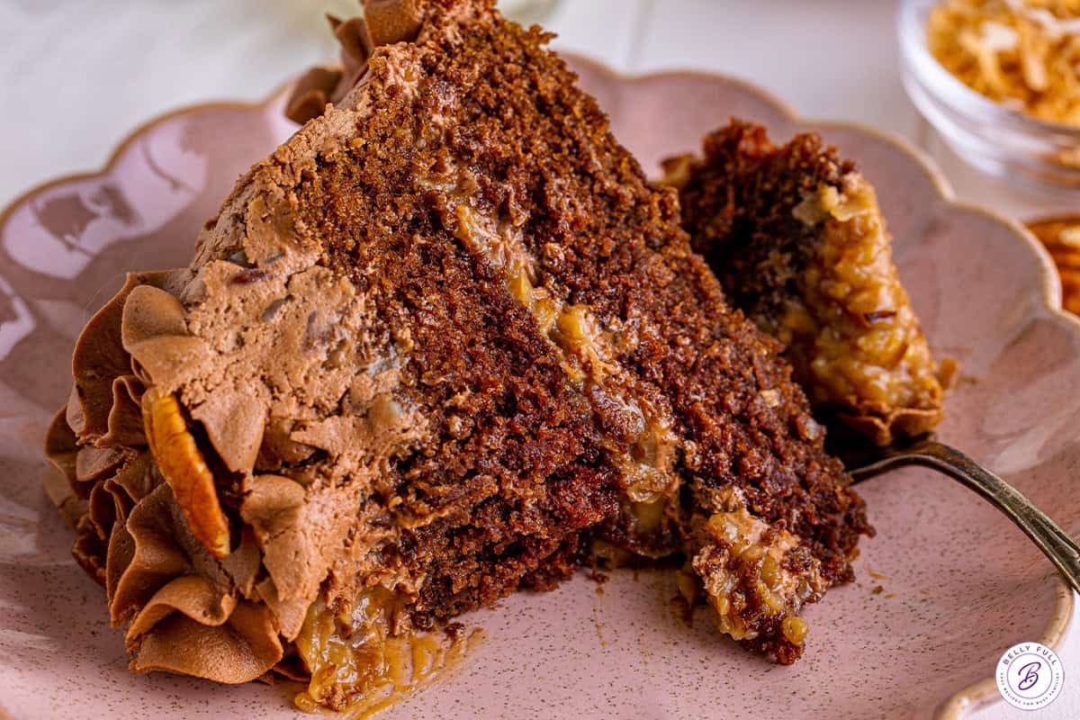 Slice of German chocolate cake on a plate with a fork.