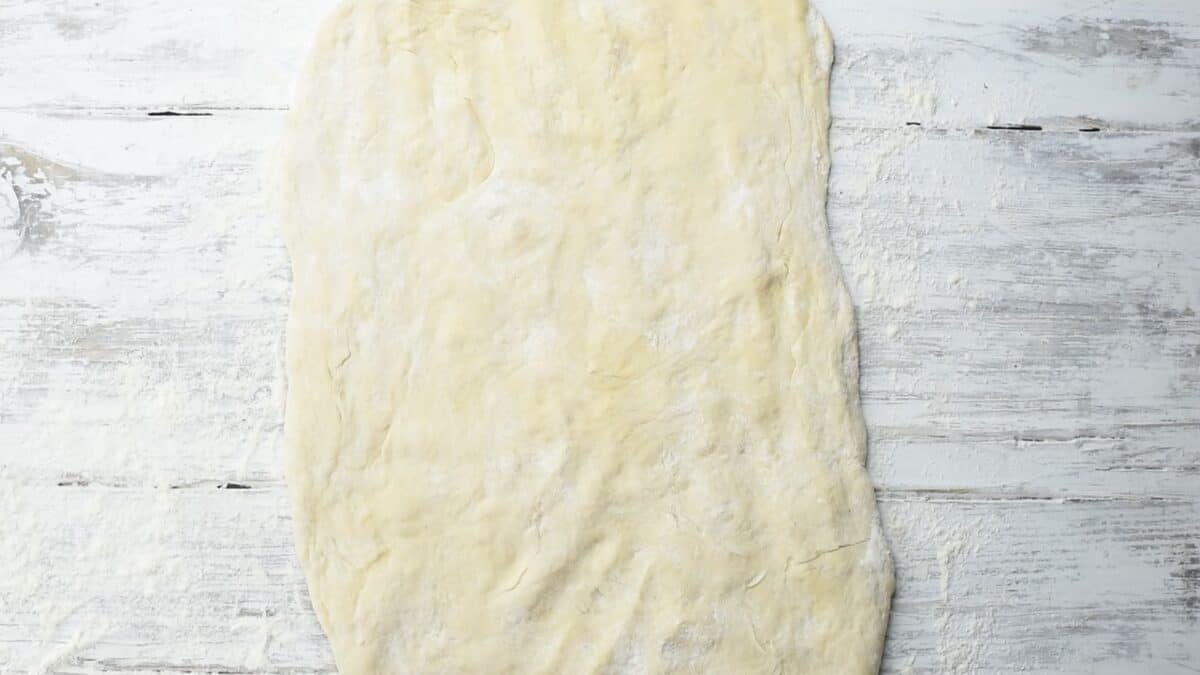 Sufganiyot dough in a rectangle on a countertop.