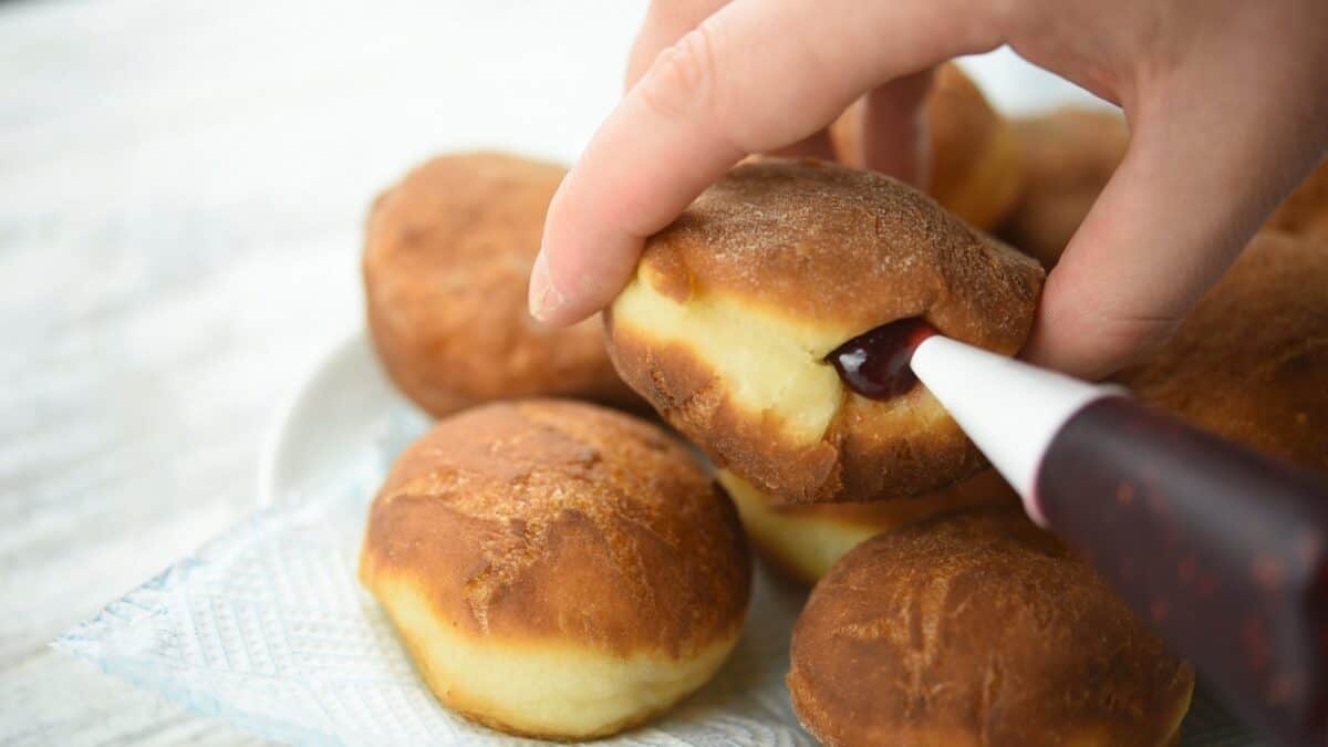 Filling the donuts with jam.