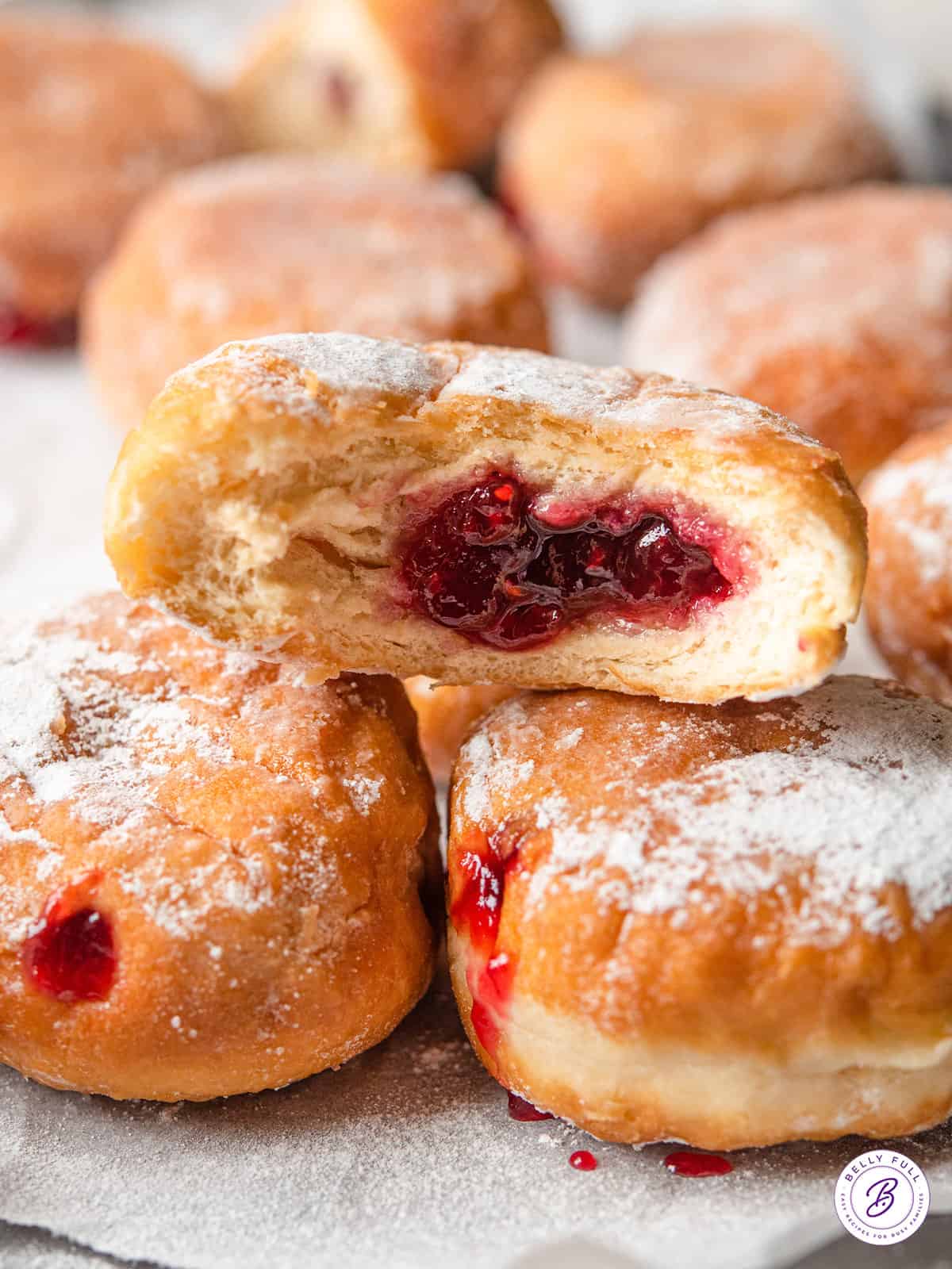 bite of jelly donut with raspberry jelly oozing out