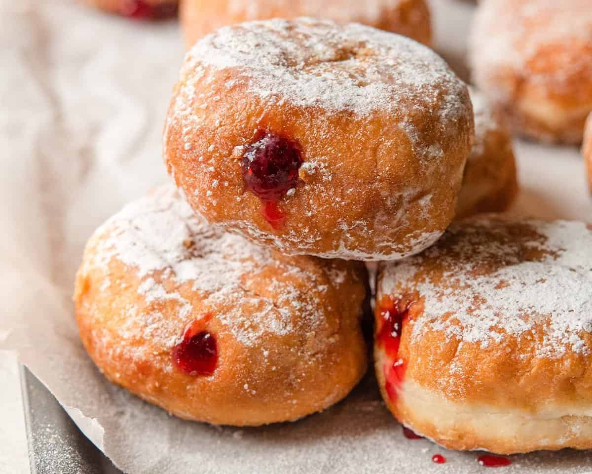 3 sufganiyot on a cookie sheet.