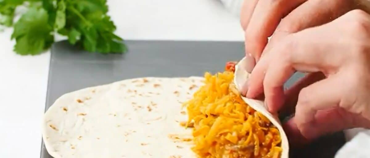 Rolling up a tortilla.