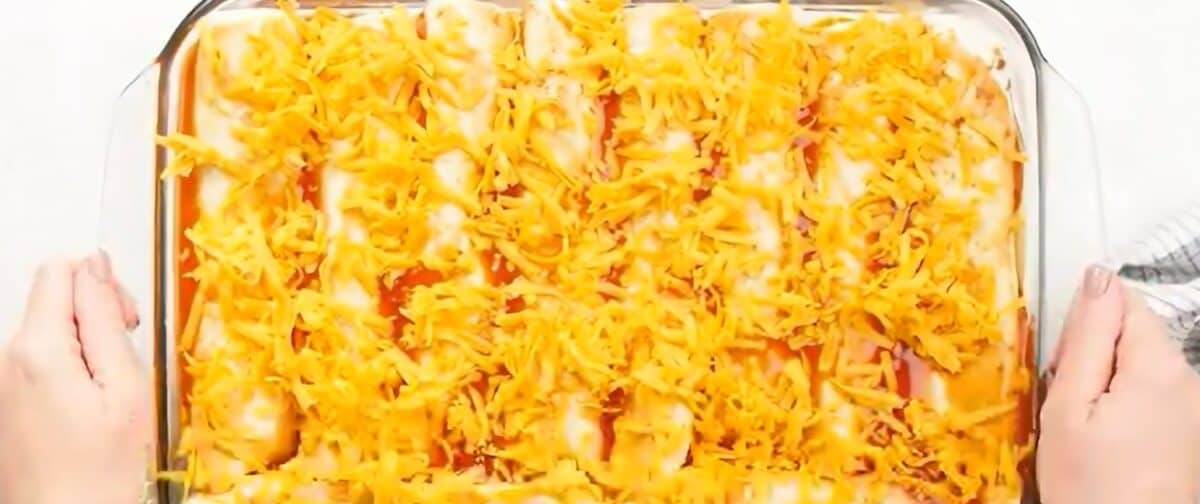 Beef enchiladas in a baking dish ready to go into the oven.