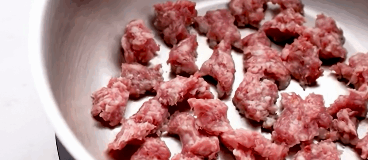 Browning the pieces of sausage in a skillet. 