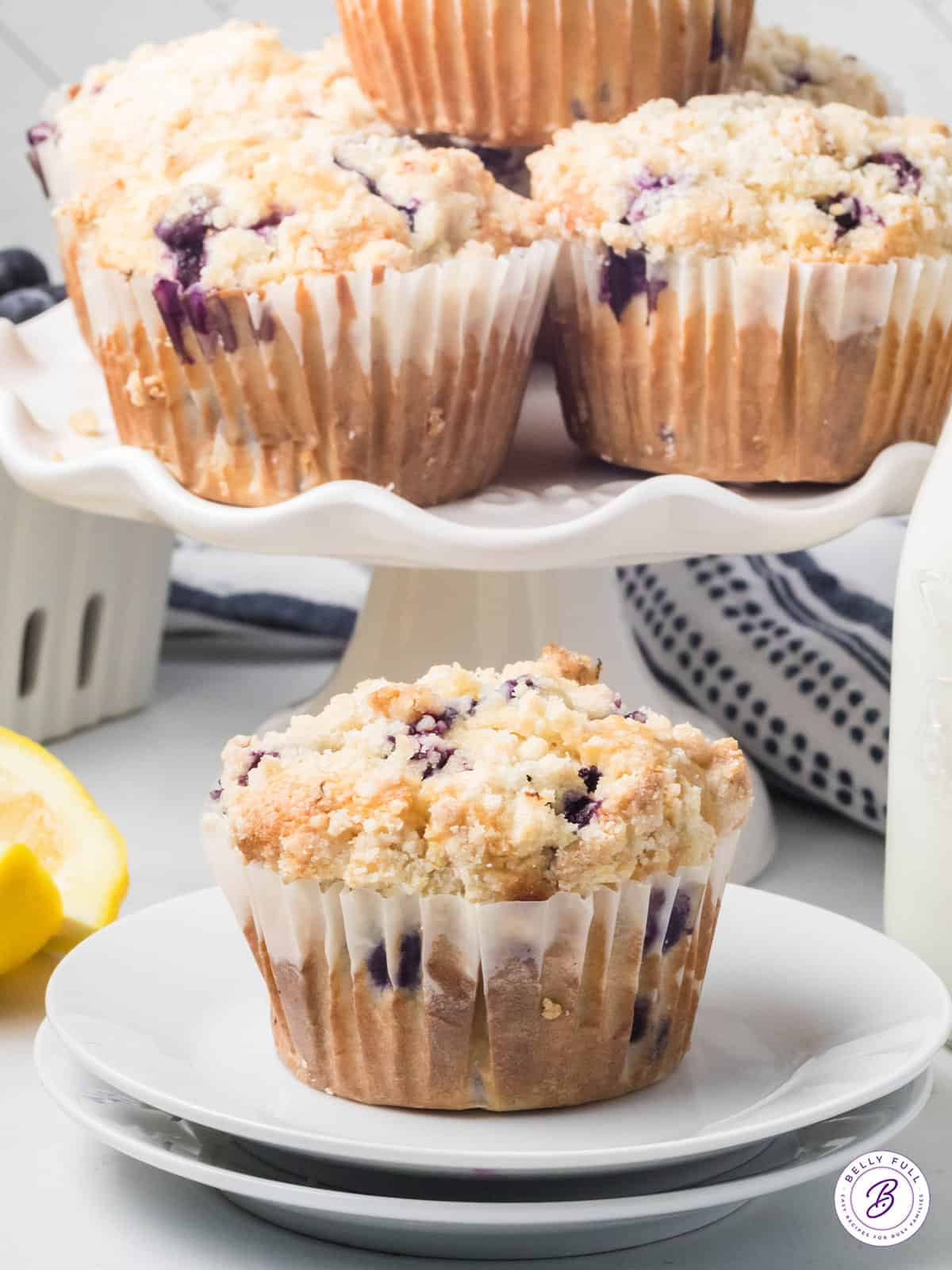 blueberry muffins on cake stand and one on plate