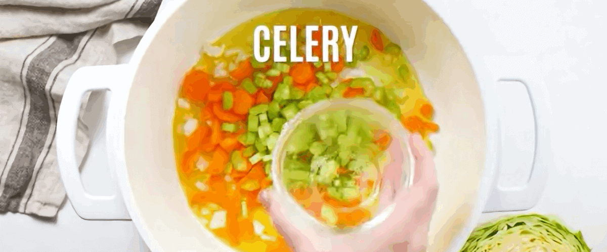 Sauteeing the vegetables in a white pot.