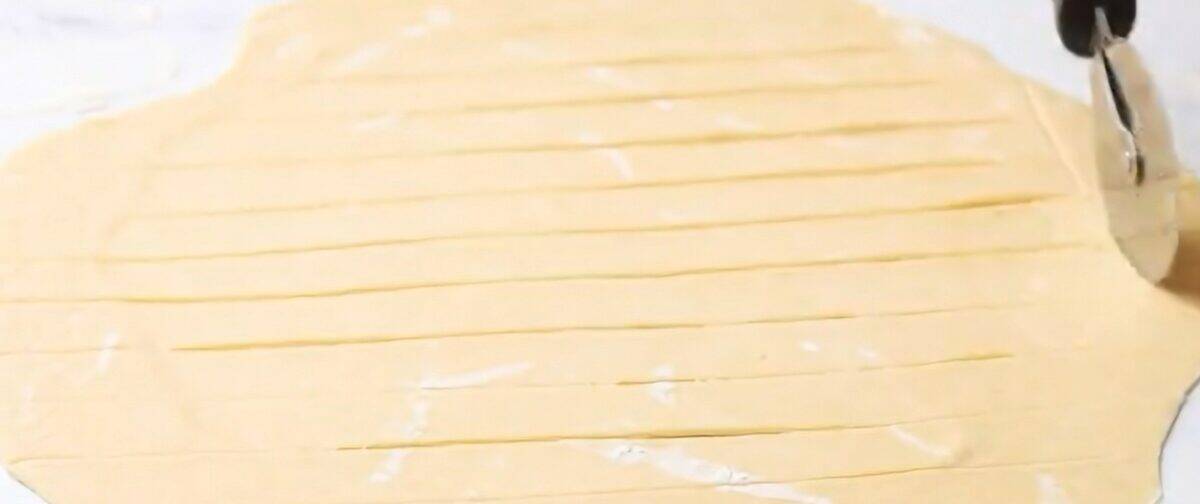Cutting the dumpling dough with a pizza cutter. 