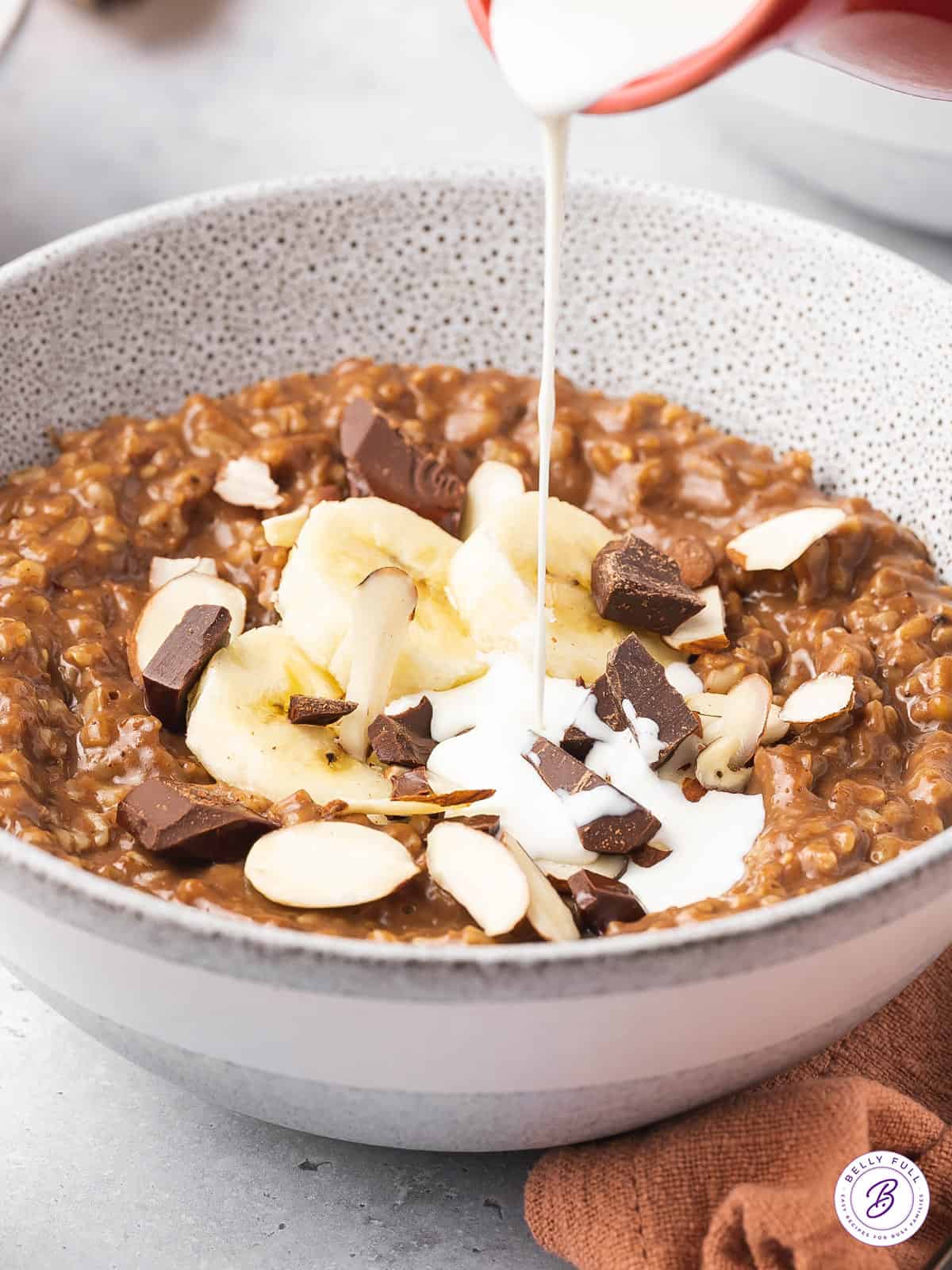 cream being poured into bowl of oatmeal