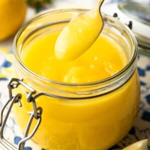 spoonful of lemon curd over a glass jar