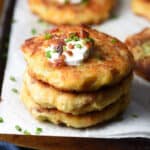 stacked of 3 mashed potato cakes topped with sour cream and bacon