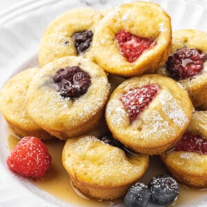 stack of mini pancake muffins with berries on white plate