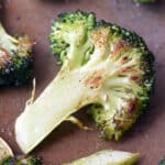 close up roasted broccoli floret on baking sheet