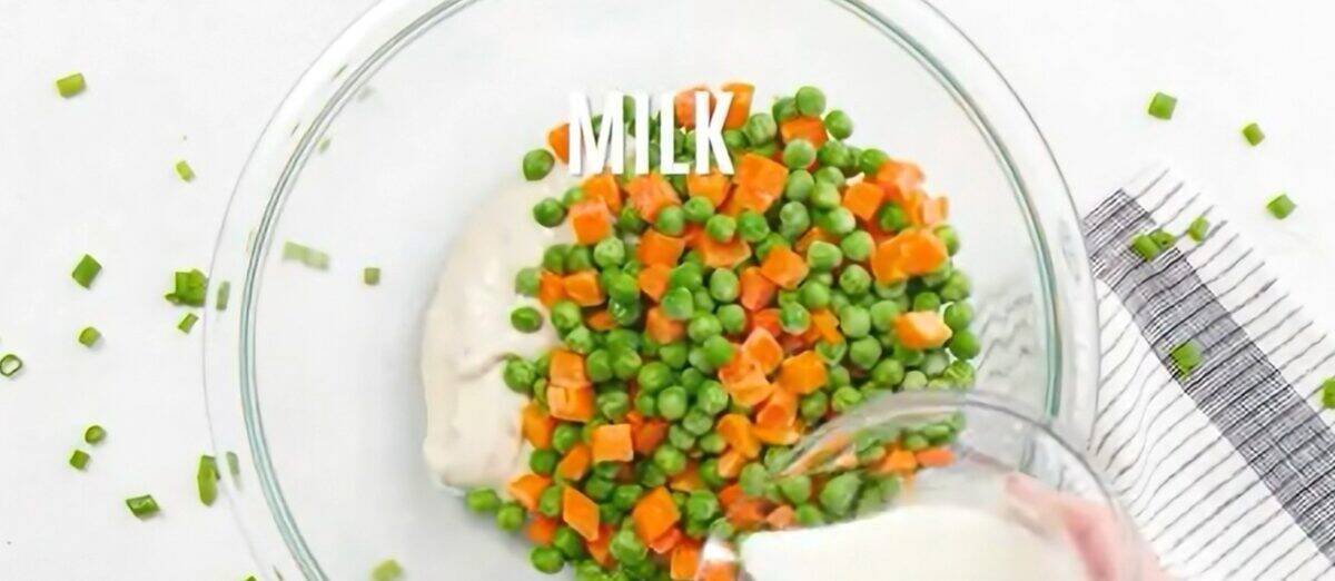 Making the soup mixture with peas, carrots, cream of mushroom soup, milk, and cheese.