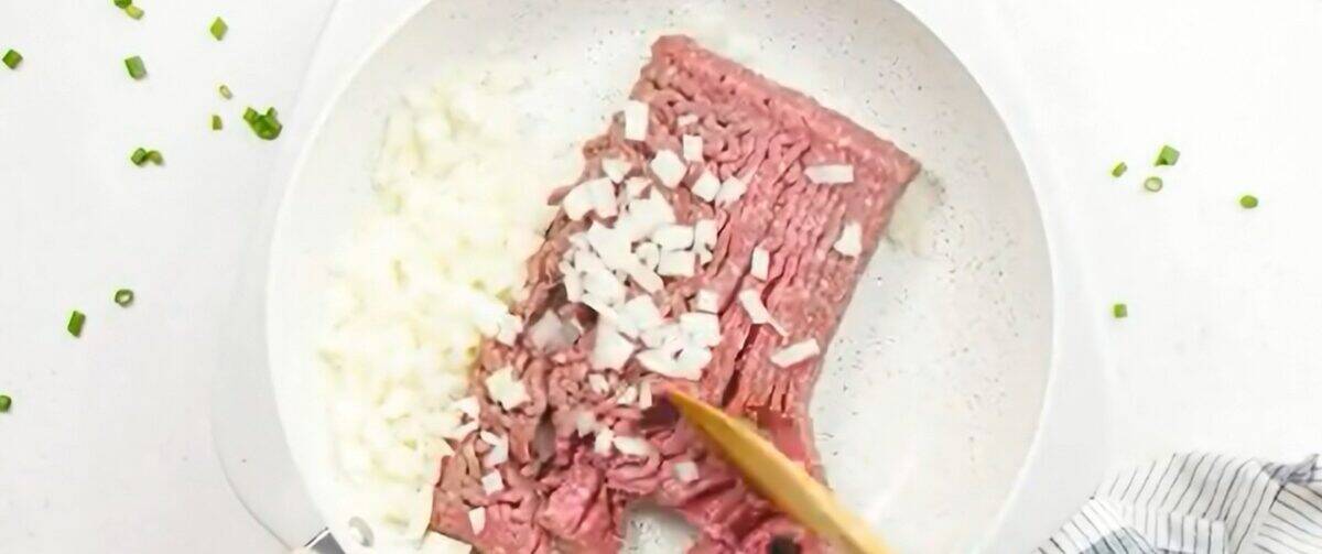 Cooking ground beef with onions in a skillet.