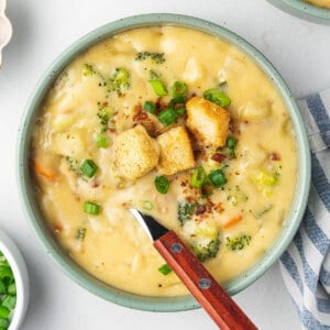 overhead bowl with spoon of cheese soup with croutons