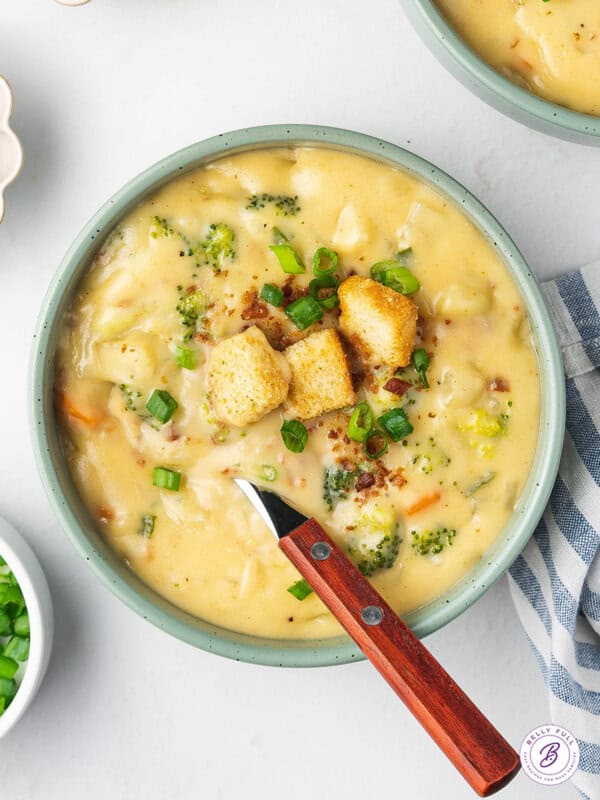overhead bowl with spoon of cheese soup with croutons