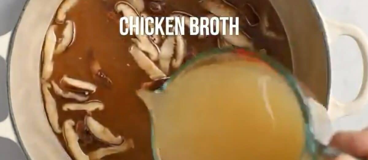 Adding broth to the pot.