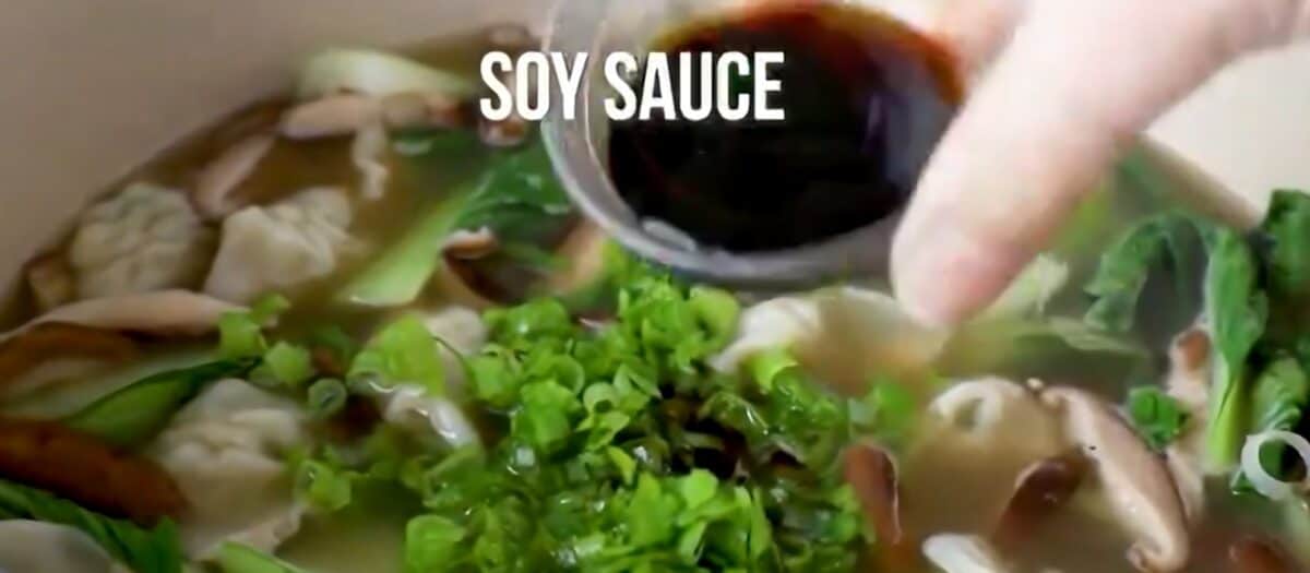 Adding scallions, soy sauce, and wine to the pot.